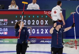 　混合ダブルス１次リーグ、カナダ戦に勝利し、ガッツポーズする英国ペア＝７日、コルティナダンペッツォ（ロイター＝共同）