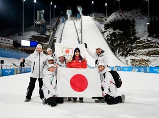 　女子個人ノーマルヒルで銅メダルを獲得し、チームスタッフらと喜ぶ丸山希（右から３人目）＝プレダッツォ（共同）