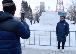 　さっぽろ雪まつりの会場で雪像と写真を撮る人＝１１日午後、札幌市