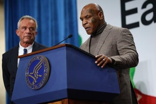 　講演するマイク・タイソン氏。左はケネディ米厚生長官＝１１日、ワシントン（ゲッティ＝共同）