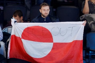 　アイスホッケー男子の米国-デンマーク戦の会場で、グリーンランドの旗を掲げる観客。「ＩＣＥ　ＯＵＴ」と書かれていた＝１４日、イタリア・ミラノ（共同）
