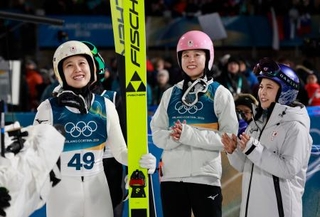 　女子個人ラージヒルを終え、勢藤優花（中央）、高梨沙羅（右）らと笑顔を見せる丸山希＝プレダッツォ（共同）