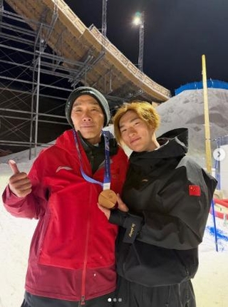 　スノーボード男子の中国代表、蘇翊鳴が投稿した佐藤康弘コーチ（左）とのツーショット写真。銅メダルを首にかけてコーチの誕生日を祝った（蘇のインスタグラムから、共同）