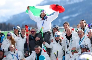 　アルペンスキー女子スーパー大回転で金メダルを獲得し、国旗を掲げて喜ぶイタリアのフェデリカ・ブリニョネ＝１２日、コルティナダンペッツォ（ロイター＝共同）