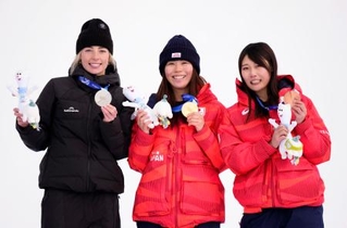 　ミラノ・コルティナ冬季五輪のスノーボード女子スロープスタイルで金メダルを獲得し、笑顔を見せる深田茉莉（中央）。右は銅メダルの村瀬心椛＝１８日、イタリア・リビーニョ（共同）
