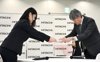 　春闘の要求書を提出する日立労組の半沢美幸中央執行委員長（左）＝１９日午後、東京都内