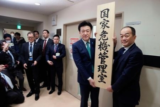 　「国家危機管理室」の看板をかける木原官房長官（右から２人目）＝２０日午前、内閣府