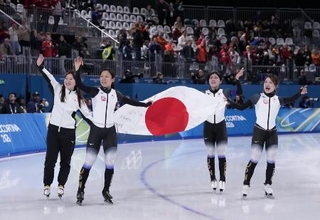 　ミラノ・コルティナ冬季五輪のスピードスケート女子団体追い抜きで銅メダルを獲得し、日の丸を掲げ場内を回る（左から）堀川桃香、高木美帆、野明花菜、佐藤綾乃＝１７日、イタリア・ミラノ（共同）