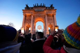 　ミラノ・コルティナ冬季五輪の聖火台が設置されている「平和の門」で写真を撮る人たち＝２１日、イタリア・ミラノ（共同）