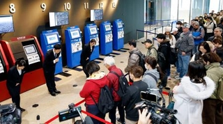 　訪れた観光客に向かい「天望デッキ」の営業再開をアナウンスする東京スカイツリーの従業員（左奥）＝２６日午前、東京都墨田区