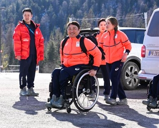　ミラノ・コルティナ冬季パラリンピックの選手村に到着したアルペンスキー男子座位の森井大輝（中央）＝２８日、イタリア・コルティナダンペッツォ（共同）