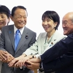 　自民党の臨時総務会で手を取り合う（左から）有村治子総務会長、麻生太郎副総裁、高市早苗総裁、鈴木俊一幹事長＝２０２５年１０月、東京・永田町の党本部