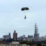 　沖縄県の米軍嘉手納基地で実施したパラシュート降下訓練で着地する米兵＝３日午後１時