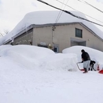 　建物の周囲を除雪する人たち＝２日、青森市