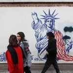 　５日、イラン・テヘランで、反米を訴える壁画の前を通る女性（ＭＡＪＩＤ　ＡＳＧＡＲＩＰＯＵＲ／ＷＡＮＡ提供・ロイター＝共同）