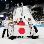 　女子個人ノーマルヒルで銅メダルを獲得し、チームスタッフらと喜ぶ丸山希（右から３人目）＝プレダッツォ（共同）