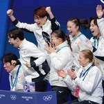 　団体男子ＳＰの演技を終え、得点を確認し喜ぶ鍵山優真（左から２人目）＝ミラノ（共同）