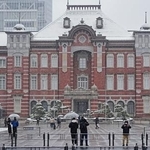 　雪が降る中、ＪＲ東京駅前を訪れた人たち＝８日午前