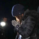 　１９４キロ死亡事故現場で手を合わせる遺族＝９日夜、大分市