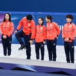 　フィギュアスケート団体の表彰台の前で靴のブレードを気にする木原龍一（左から３人目）＝８日、ミラノ（共同）