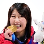 　女子ビッグエアで獲得した金メダルをかじるポーズで笑顔の村瀬心椛＝リビーニョ（共同）