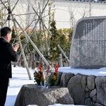　慰霊碑に手を合わせる三幸製菓の牛腸栄一社長＝１０日午前、新潟県村上市