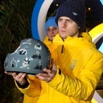 　ロシアの攻撃で犠牲となったアスリートたちの顔写真を張ったヘルメットを手にするスケルトン男子ウクライナ代表のウラジスラフ・ヘラスケビッチ＝１０日、コルティナダンペッツォ（共同）