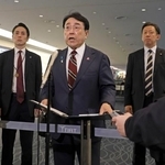 　出発前、羽田空港で記者団の取材に応じる赤沢経産相（中央）＝１１日午前