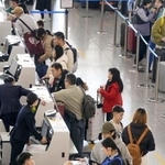 　春節の帰省や旅行に伴う特別輸送態勢「春運」が始まり、北京首都国際空港の日本便を扱うカウンターで搭乗手続きをする人たち＝２日（共同）