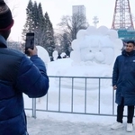 　さっぽろ雪まつりの会場で雪像と写真を撮る人＝１１日午後、札幌市