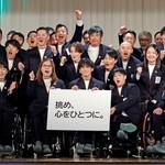 　ミラノ・コルティナ冬季パラリンピック日本選手団の結団式で、スローガン「挑め、心をひとつに。」を掲げ写真に納まる選手たち＝１２日午後、東京都内
