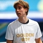 　スピードスケート男子１万メートルで金メダルを獲得し「ゴールデン・ボーイ」と書かれたＴシャツ姿を披露したメトジェイ・イレク＝１３日、ミラノ（ロイター＝共同）