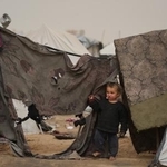 　１４日、パレスチナ自治区ガザで避難民が暮らすテントと子ども（ＡＰ＝共同）