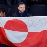 　アイスホッケー男子の米国-デンマーク戦の会場で、グリーンランドの旗を掲げる観客。「ＩＣＥ　ＯＵＴ」と書かれていた＝１４日、イタリア・ミラノ（共同）