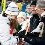 　女子個人ラージヒルを終え、母信子さんの写真に触れる丸山希。右は父守さん＝プレダッツォ（共同）