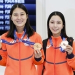 　羽田空港に到着しメダルを披露する、ノルディックスキージャンプ女子の丸山希（左）と高梨沙羅＝１８日午前