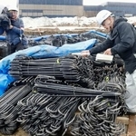 　「クリアランス金属」を再利用した鉄筋の放射線量を測定する担当者（右）＝１８日午後、福井県南越前町