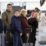 　羽田空港の国際線出発ロビーで手続きをする訪日客ら＝１８日午前