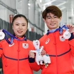 　フィギュアスケート団体で獲得した銀メダルを掲げる、アイスダンスの吉田唄菜（左）と森田真沙也＝京都府宇治市