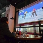 　韓国仁川市のパブで、ケーブルテレビ局が放送するミラノ・コルティナ冬季五輪の競技を見る市民＝１０日（共同）