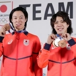 　記者会見を終え、メダルを手にポーズをとるノルディックスキー・ジャンプ男子の小林陵侑（左）と二階堂蓮＝１８日、イタリア・ミラノ（共同）