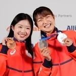 　記者会見でメダルを掲げるフィギュアスケート女子の坂本花織（右）と中井亜美＝２０日、イタリア・ミラノ（共同）