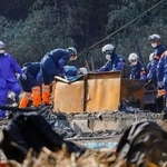 　正琳寺の住居兼本堂などが全焼した現場を調べる警察官ら＝２１日午前１０時６分、山口県下関市