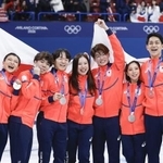 　フィギュアスケート団体で銀メダルを獲得し、日の丸を掲げる（左から）坂本花織、佐藤駿、鍵山優真、吉田唄菜、森田真沙也、三浦璃来、木原龍一＝８日、ミラノ（共同）