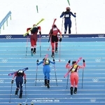 　山岳スキーの混合リレー、スキー板を外して階段を登る選手たち＝２１日、ボルミオ（ロイター＝共同）