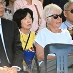 　２２日、ニュージーランドのクライストチャーチで開かれた地震の追悼式に出席した堀田めぐみさんの両親（奥）ら（共同）