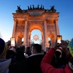 　ミラノ・コルティナ冬季五輪の聖火台が設置されている「平和の門」で写真を撮る人たち＝２１日、イタリア・ミラノ（共同）