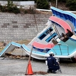 　事故に遭った遊漁船を調べる運輸安全委員会の船舶事故調査官＝２４日午前、三重県鳥羽市