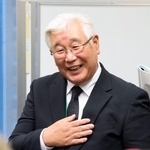 　笑顔で集会後の取材に応じる阪原弘次さん＝２５日午後、国会