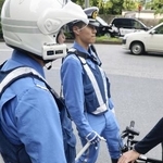 　危険な走行をしていた自転車を止めて指導する警視庁の警察官＝２０２４年、東京都千代田区